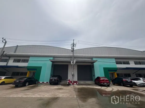 Factory for rent in Bang Phli, Samut Prakan - Modern factory facade with twin loading bays, roller shutters, and on-site parking.