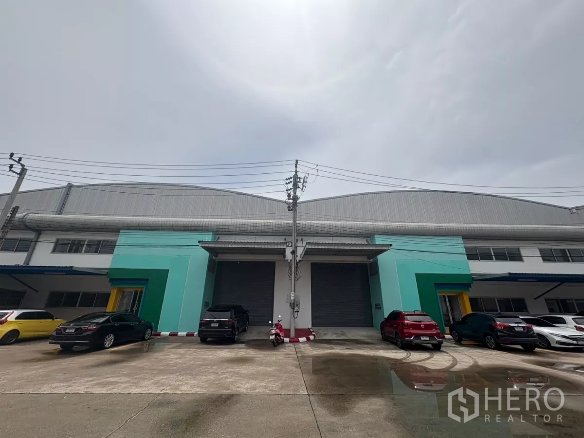 Factory for rent in Bang Phli, Samut Prakan - Modern factory facade with twin loading bays, roller shutters, and on-site parking.