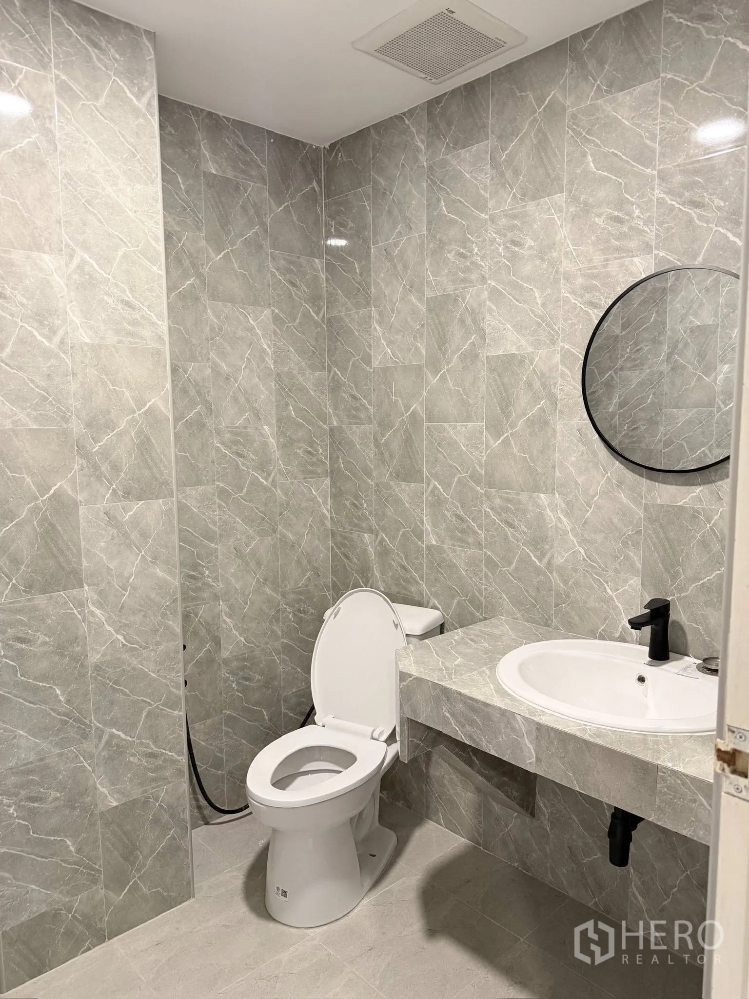 Townhouse for rent or sale in Yan Nawa, Bangkok - Second bathroom with gray tiles, countertop basin, and toilet.