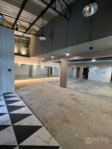 零售空间 出租在Phaya Thai, Bangkok - 一层开放式空间，层高挑高，金属梁架，镜面墙与柱体，入口三角拼花地砖。
