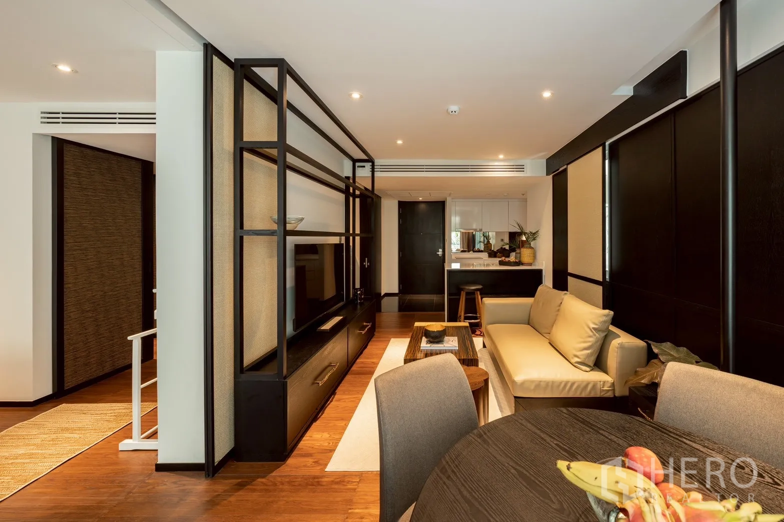 คอนโด for rent or sale in Pathum Wan, Bangkok - โต๊ะทานอาหารมุมมองสู่ผนังทีวี โซฟา และทางเข้าครัว