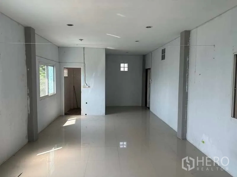 Warehouse for rent in Pathum Thani - Upper-floor office space with windows and doorway to a restroom.