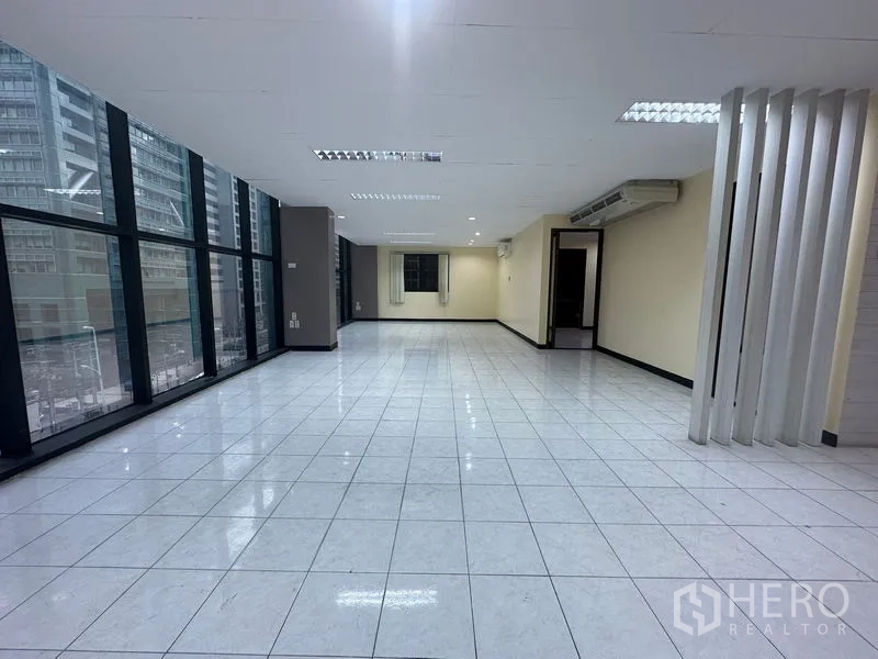 Office Space for rent in Bang Rak, Bangkok - Expansive workspace featuring a full-height glass wall with urban views.