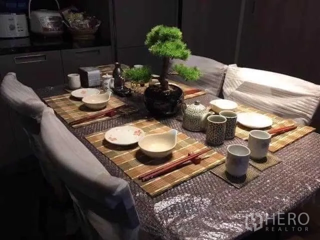 Condominium for rent in Watthana, Bangkok - Close-up of a dining table set for four with tea set and a bonsai centerpiece.