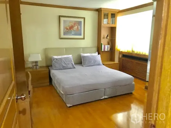 公寓 出租在Watthana, Bangkok - 主卧配双人床、木地板、内置书架与大窗户。