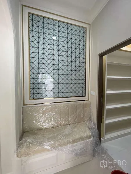บ้าน ขายในThawi Watthana, Bangkok - มุมนั่งเล่นติดหน้าต่าง พร้อมเบาะบุนวมและแผงตกแต่งลายเรขาคณิต