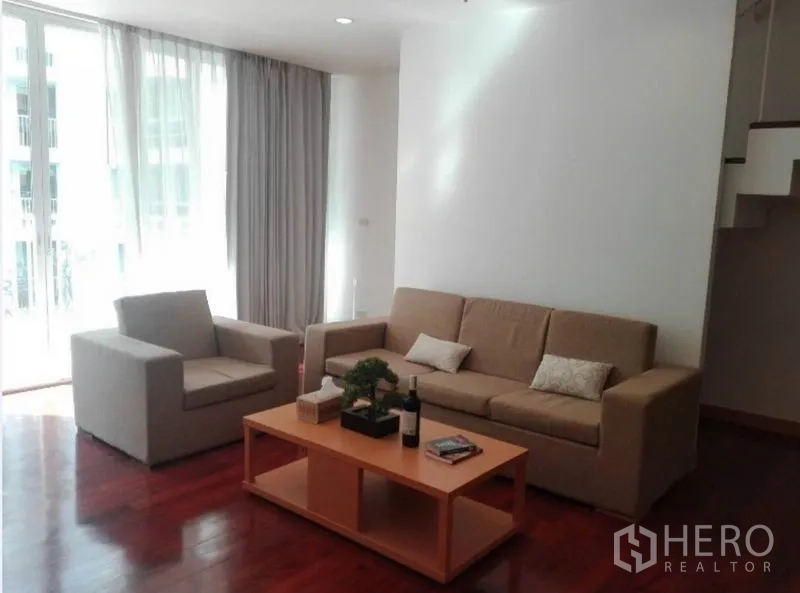 公寓 出租在Watthana, Bangkok - 明亮客厅，沙发组合与茶几，落地窗与纱帘。