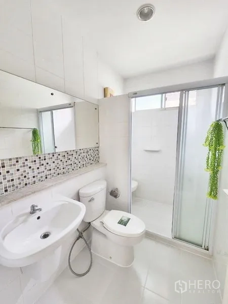 独立式住宅 出租在Prawet, Bangkok - 干净白色卫浴，马赛克挡水边与玻璃淋浴间。