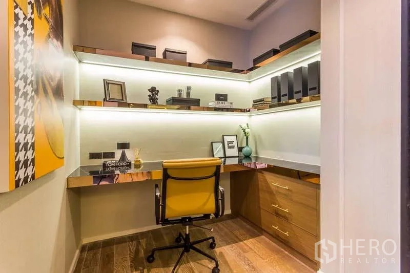 Condominium for rent in Pathum Wan, Bangkok - Built-in home office with illuminated shelves and wood flooring.