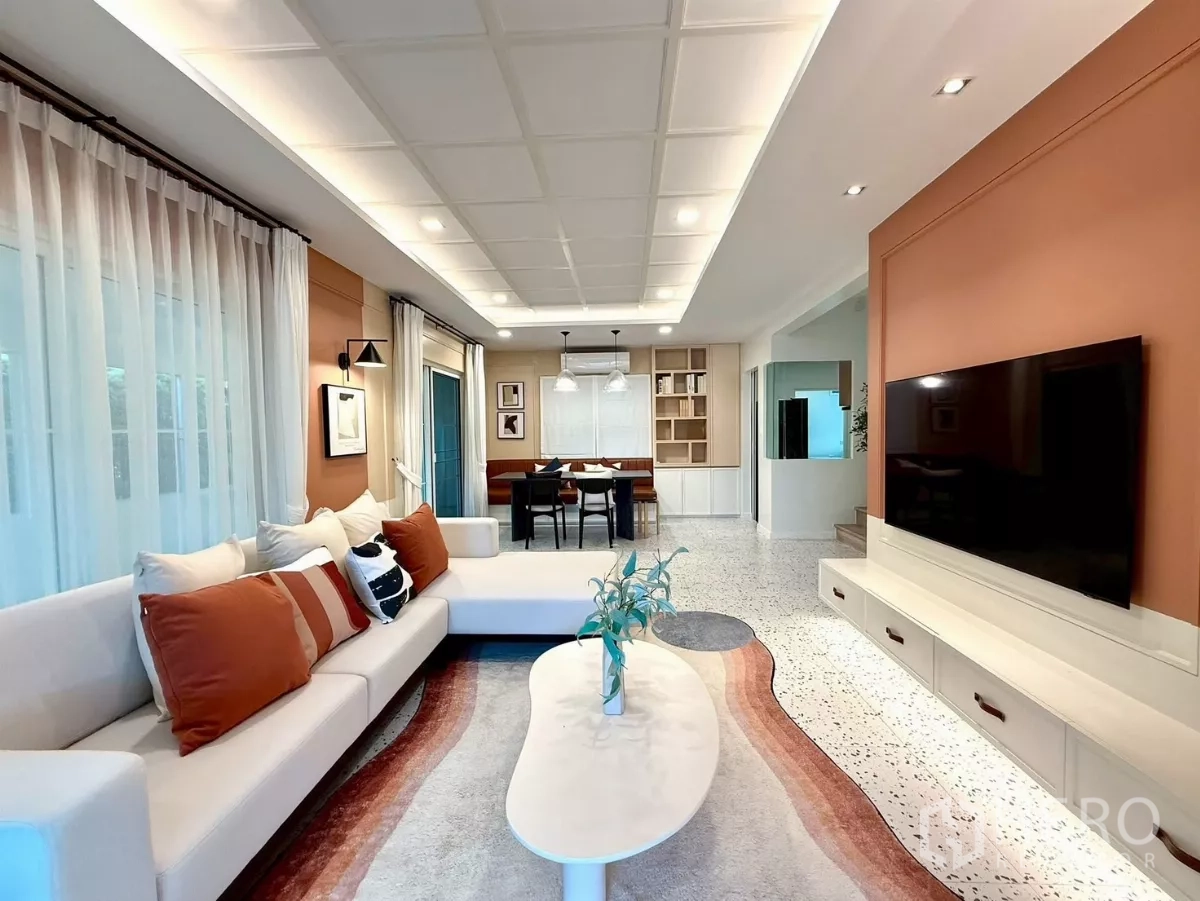 Detached House for rent in Bang Phli, Samut Prakan - Stylish living room with L-shaped sofa, built-in TV wall and soft lighting.