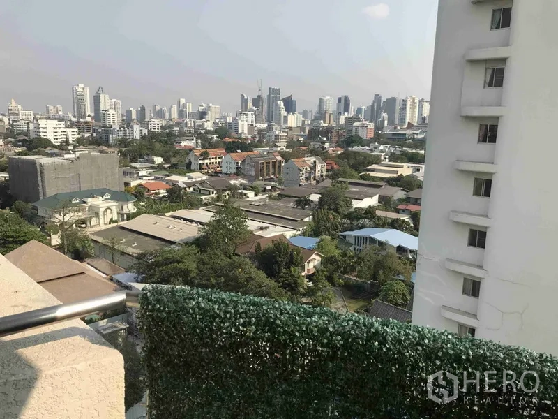Condominium for rent or sale in Watthana, Bangkok - Balcony with privacy hedge and open skyline view across Watthana district.