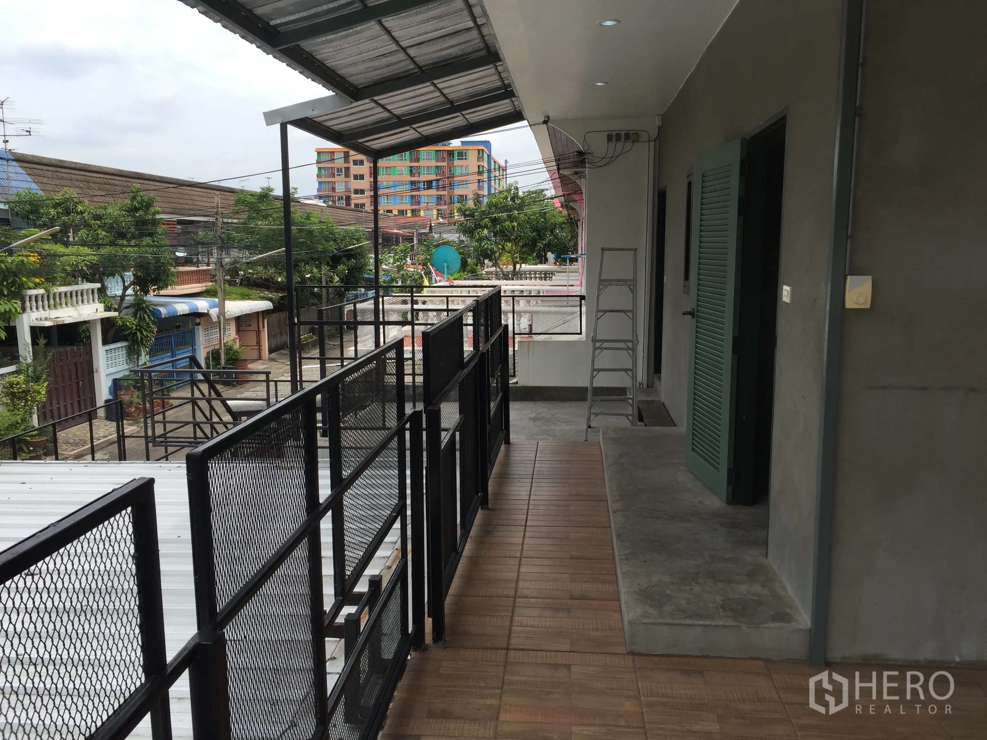 独立式住宅 出租在Din Daeng, Bangkok - 二层走道配金属栏杆，眺望低层社区与绿意。