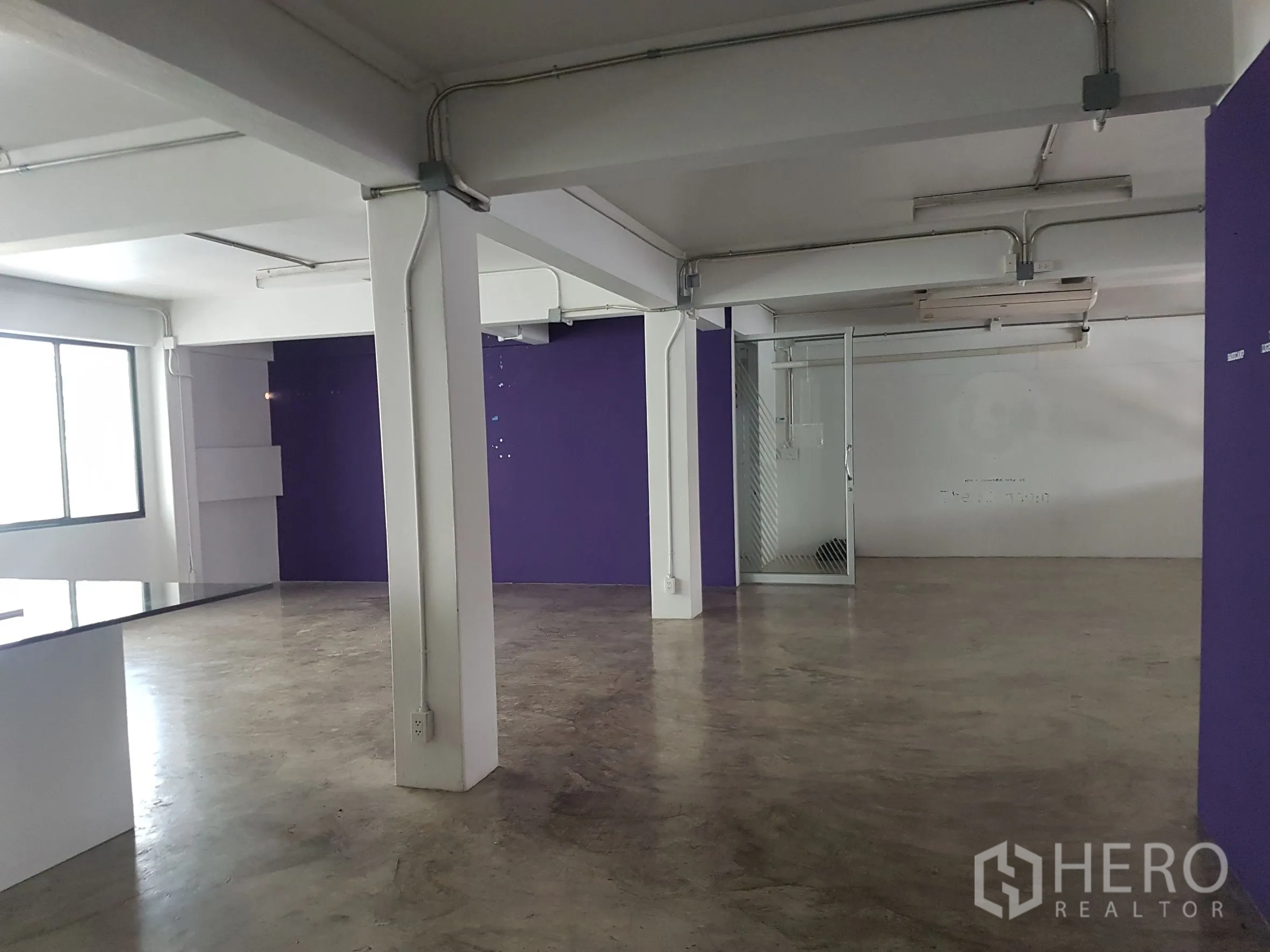 Home Office for sale in Khlong Toei, Bangkok - Alternate angle of the open-plan floor showing purple wall and mesh door.