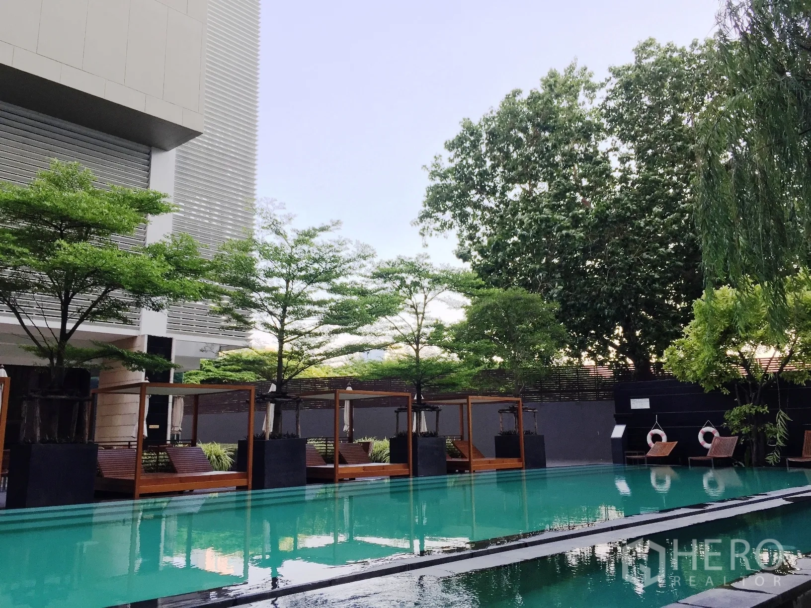 公寓 出租或出售在Khlong Toei, Bangkok - 户外泳池，设躺椅与凉亭，绿化环绕。