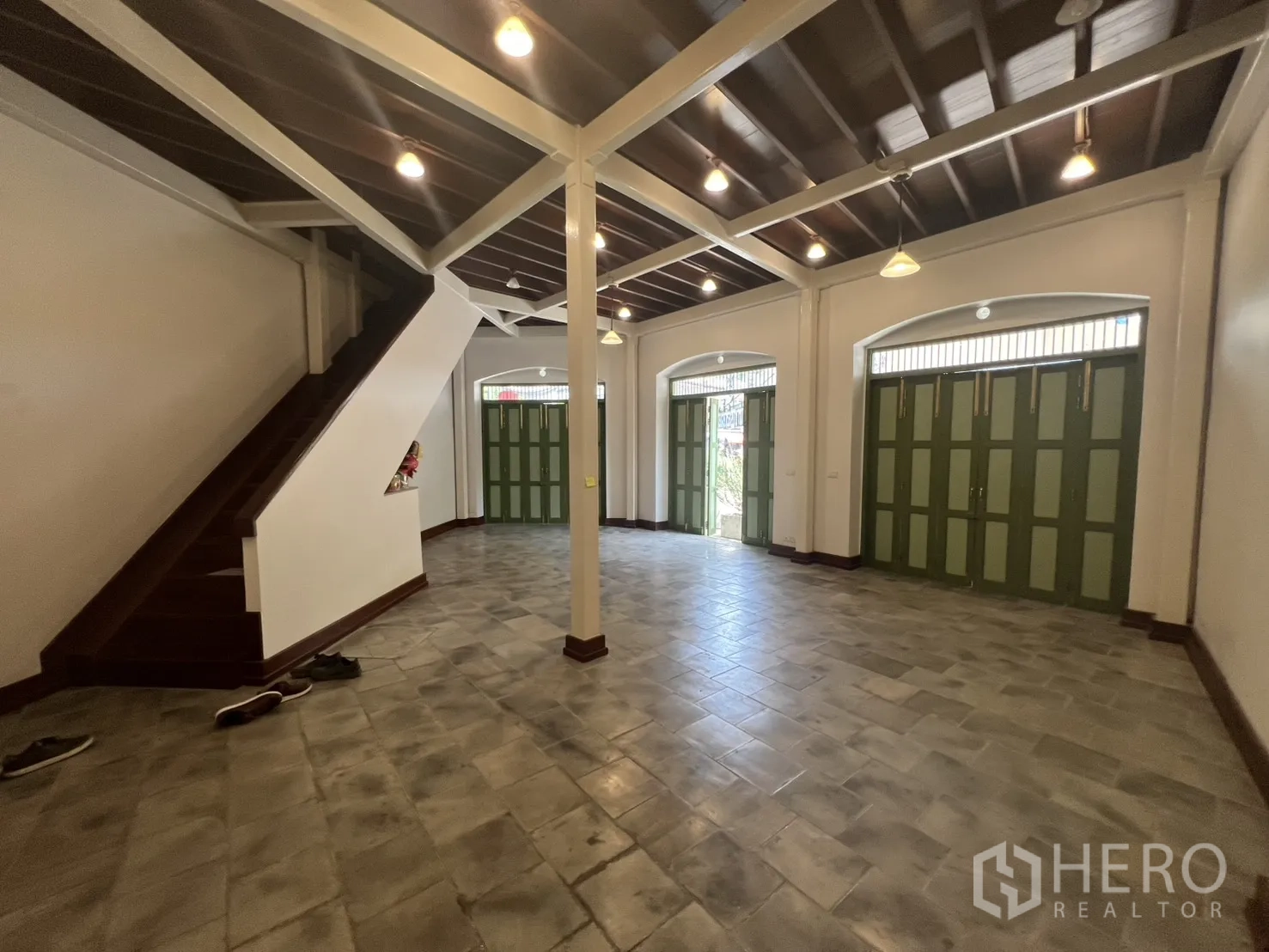 店屋 for rent in Samphanthawong, Bangkok - 开放式首层铺面，灰色地砖、通往楼上的楼梯，多组绿色百叶店门，街面曝光佳。