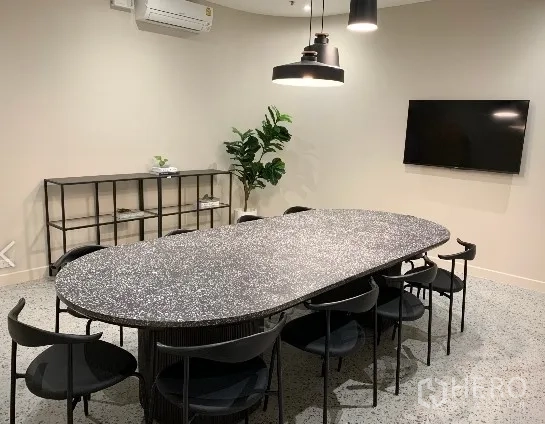 办公空间 出租在Khlong Toei, Bangkok - 现代会议室，椭圆形水磨石桌，八把黑椅，吊灯、壁挂电视与空调。