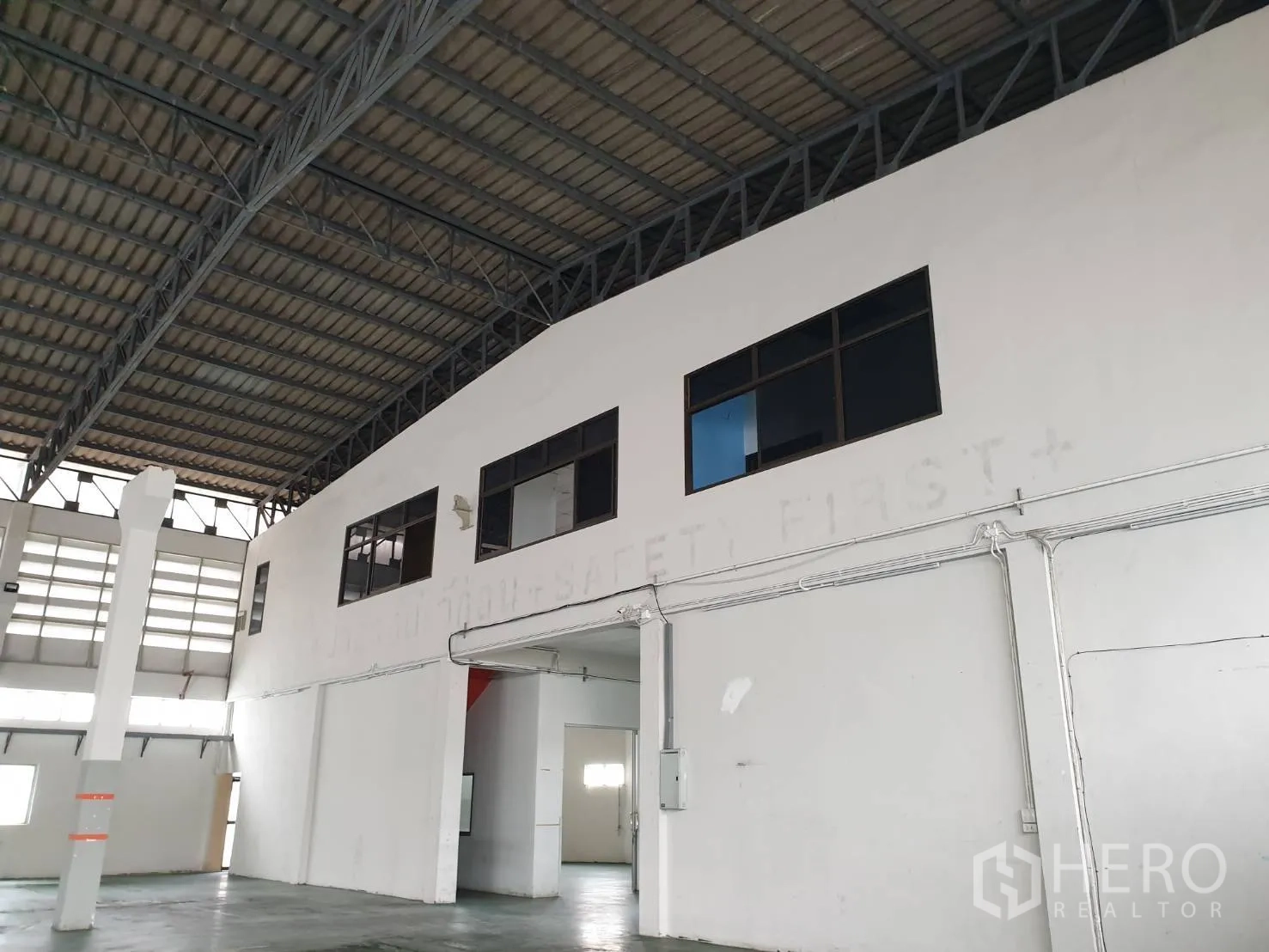 工厂 出租在Bang Pakong, Chachoengsao - 厂房内的两层办公室近景，设有窗户可俯瞰生产大厅。