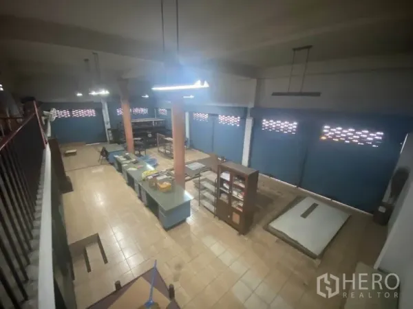Warehouse for rent in Suan Luang, Bangkok - Spacious workshop room with shelving, fluorescent lights and shuttered windows.