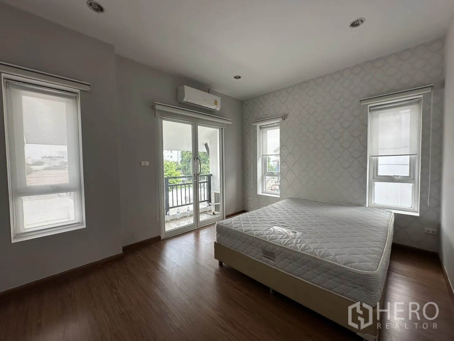 โฮมออฟฟิศ for rent in Watthana, Bangkok - ห้องนอนหลักสว่าง พื้นไม้ หลายหน้าต่าง และประตูออกสู่ระเบียง