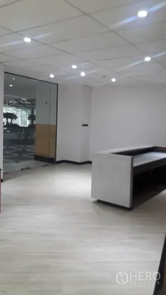 Office Space for rent in Huai Khwang, Bangkok - View from inside reception toward the glass entrance with neutral walls and spotlights.