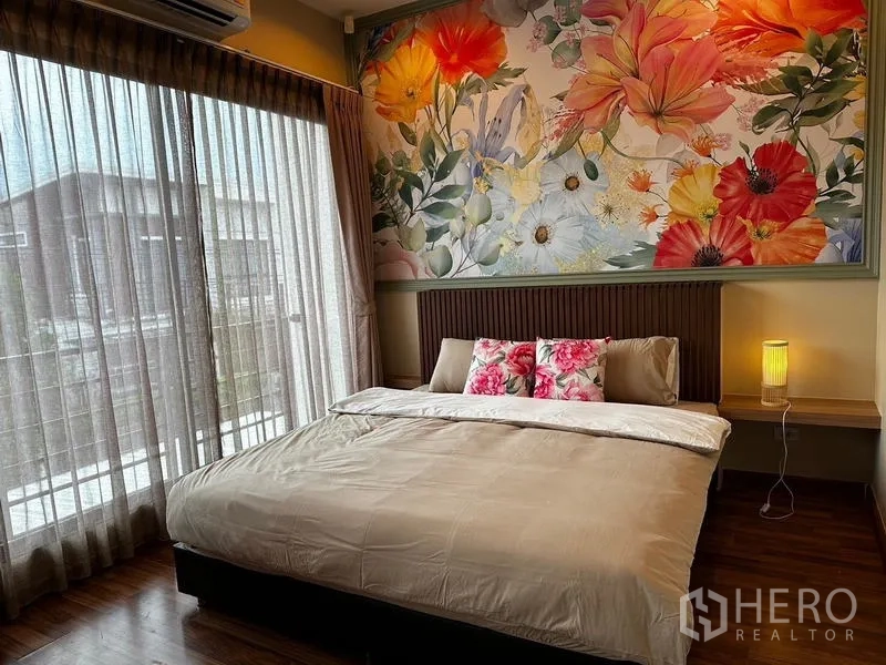 บ้าน ให้เช่าในPrawet, Bangkok - ห้องนอนใหญ่ เตียงคิง ผนังลายดอกไม้ และหน้าต่างระเบียง