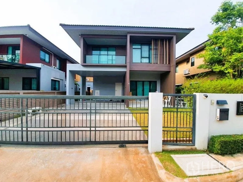 独立式住宅 出售在Pathum Thani - 现代两层独栋住宅，带电动门车道、车棚与前庭草坪。