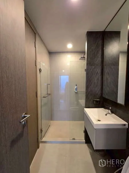 公寓 出租在Phaya Thai, Bangkok - 现代化浴室，玻璃淋浴间、洗手台与大镜子。