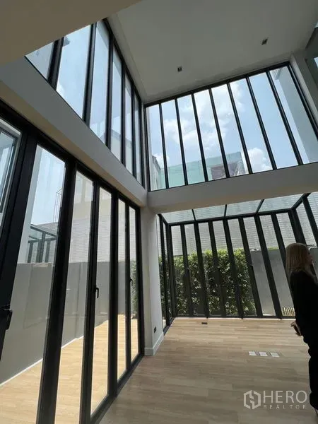 带办公室的家 出售在Wang Thonglang, Bangkok - 一层明亮空间，通高玻璃墙连接私家庭院与绿植。