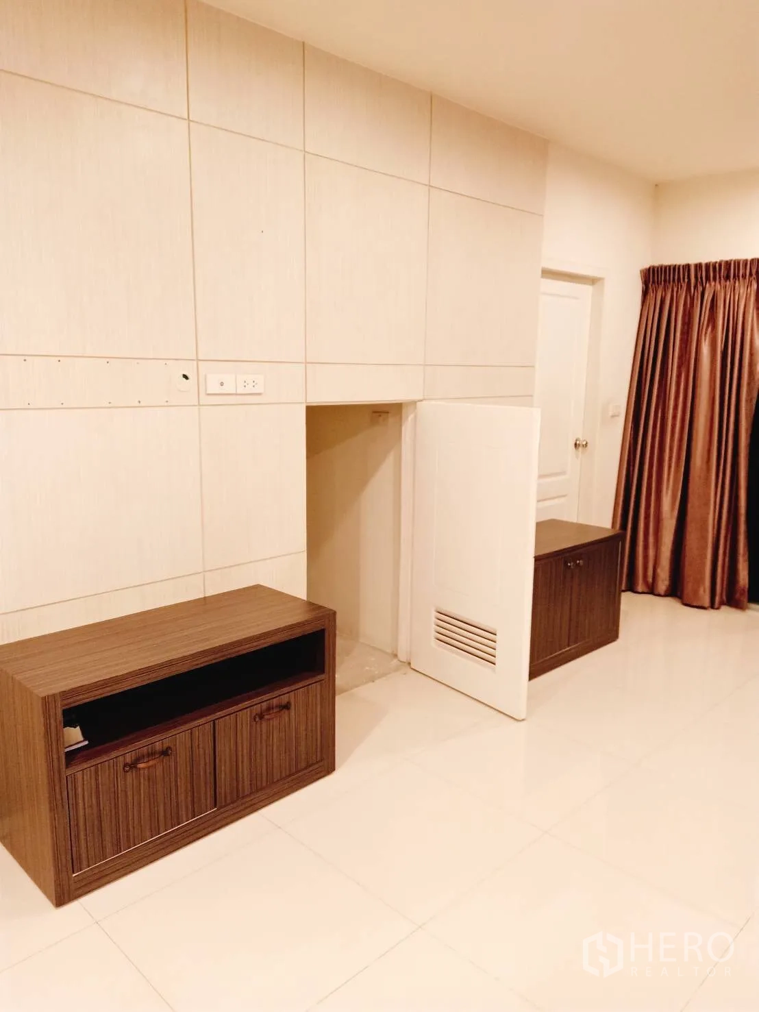 Townhouse for rent in Suan Luang, Bangkok - Ground-floor multipurpose area with tiled floor, built-in low cabinets and interior door
