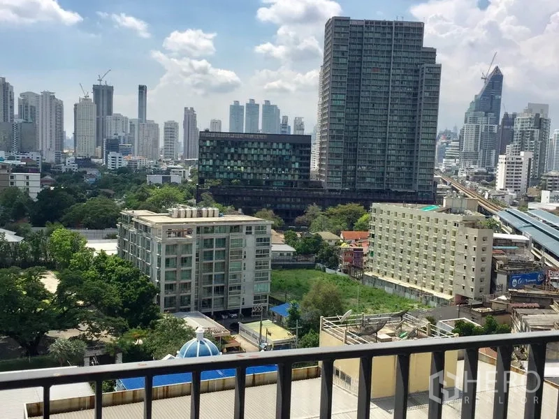 Condominium for rent in Khlong Toei, Bangkok - High-floor balcony outlook over Khlong Toei skyline and green spaces in Bangkok.