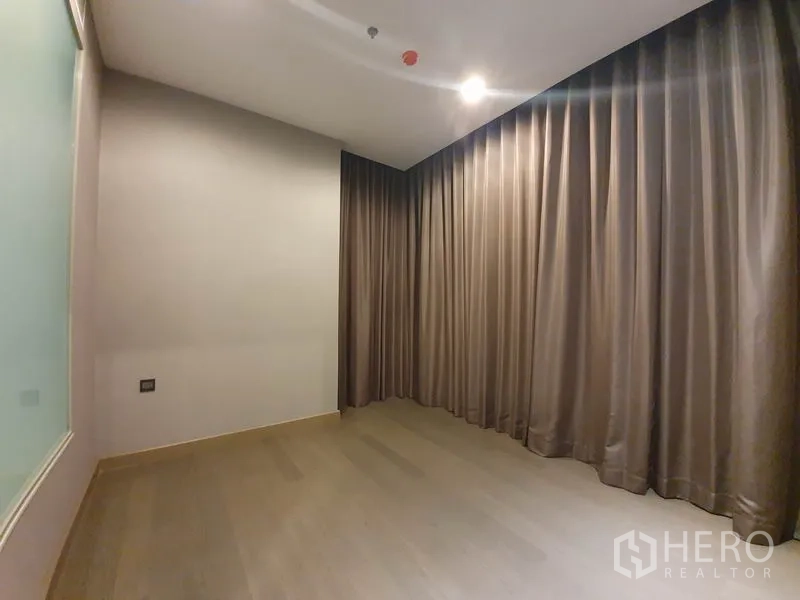 คอนโด ให้เช่าในHuai Khwang, Bangkok - ห้องนอนหรือห้องทำงานโล่ง พื้นไม้ ม่านยาวจรดพื้น แสงนวล