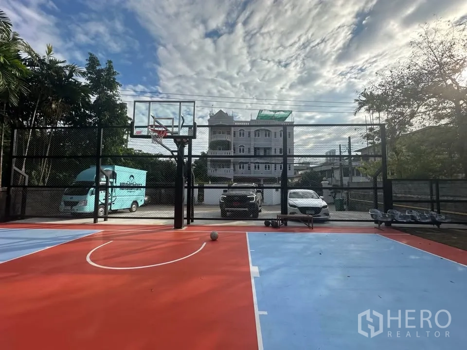 Land for rent in Watthana, Bangkok - Fenced basketball court on the Sukhumvit land with parking area and neighborhood buildings in the background near BTS Ekkamai.