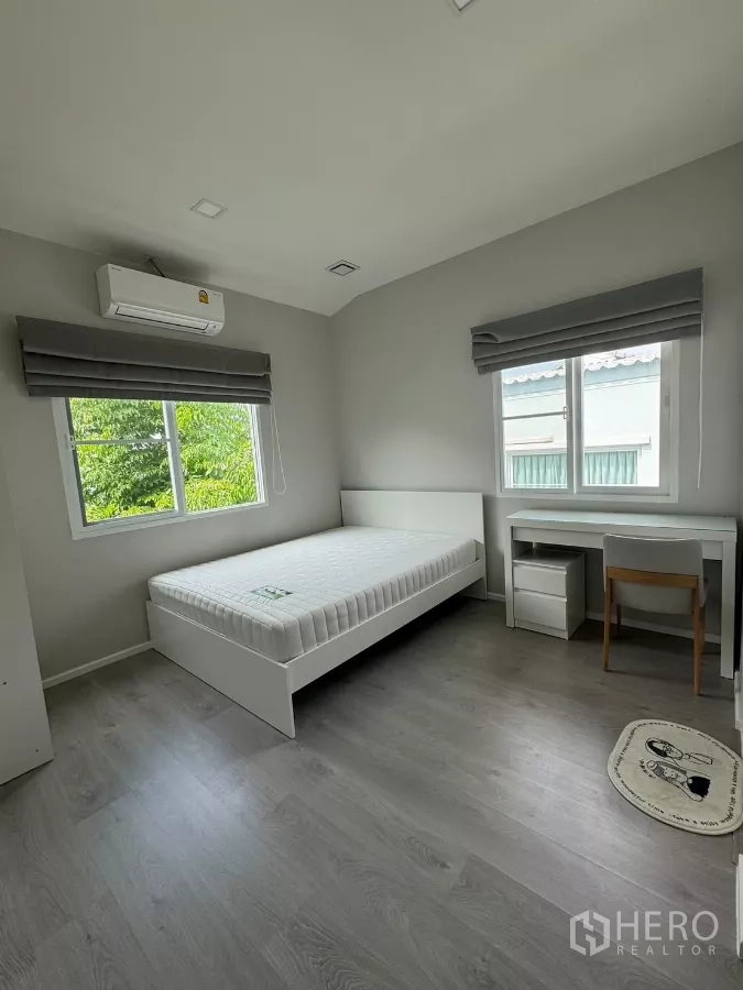 Detached House for rent in Prawet, Bangkok - Light-filled bedroom with bed, study desk, windows and air-conditioning.