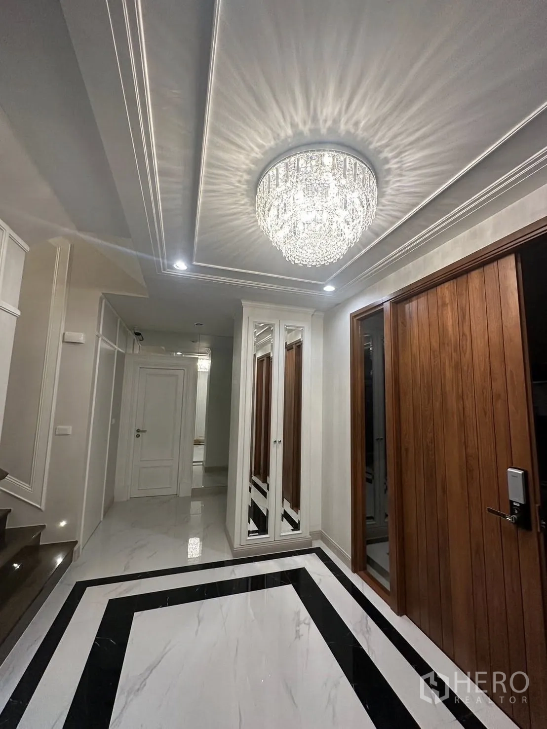 Detached House for rent or sale in Bang Kapi, Bangkok - Elegant foyer with statement crystal ceiling light, marble flooring and wood doors.