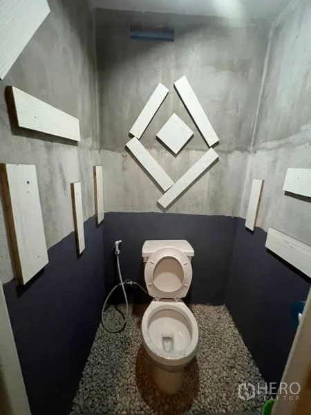 Shophouse for rent or sale in Watthana, Bangkok - Toilet cubicle with decorative wall panels and handheld bidet.