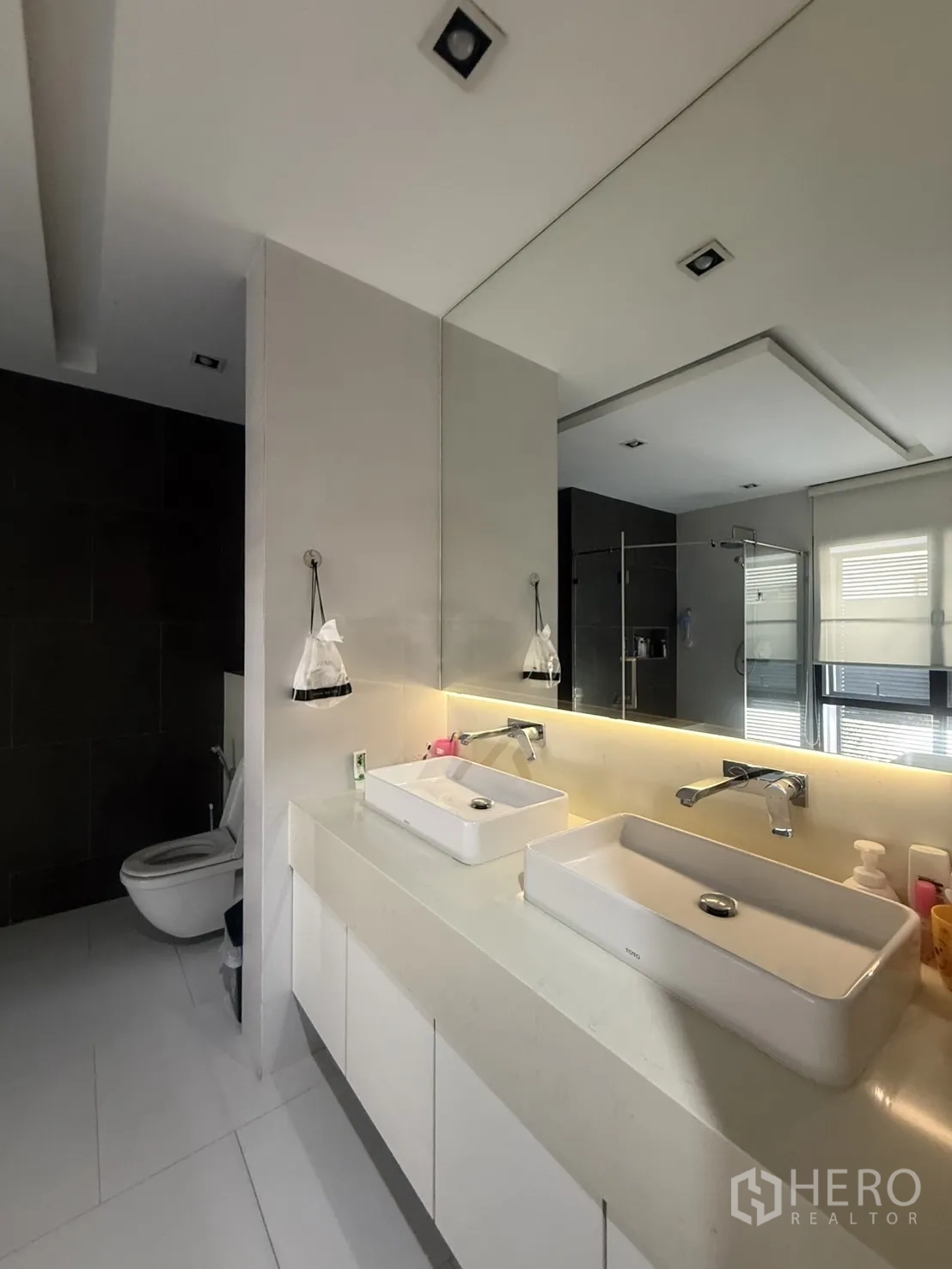 Detached House for rent in Bang Kapi, Bangkok - Contemporary bathroom with double rectangular sinks and backlit mirror.