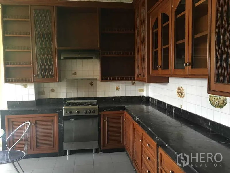 联排别墅 出租在Khlong Toei, Bangkok - L形厨房，炉灶、抽油烟机和大量木柜