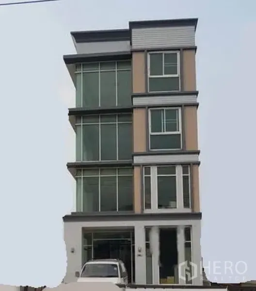 Home Office for sale in Lat Krabang, Bangkok - Four-storey modern home office facade with large glass windows and ground-level parking in Lat Krabang, Bangkok