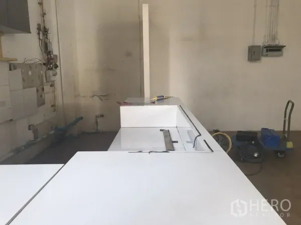 Retail Space for rent in Khlong Toei, Bangkok - Back-of-house corner showing white countertop, visible plumbing lines and utility connections ready for light F&B fit-out.