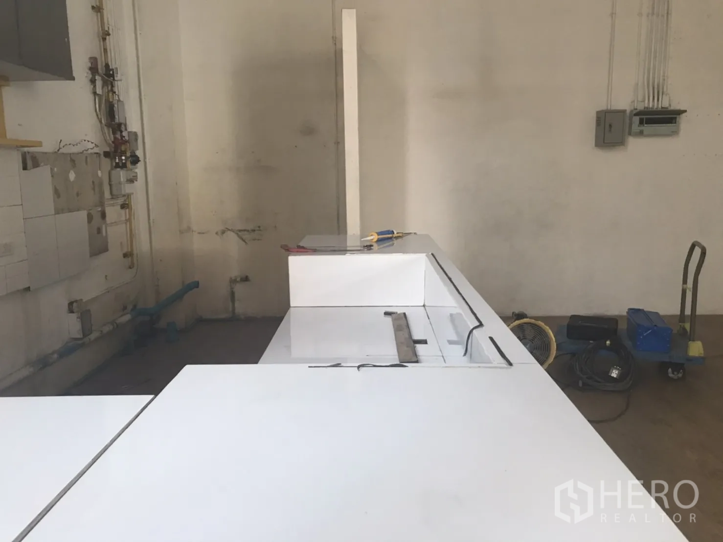 Retail Space for rent in Khlong Toei, Bangkok - Back-of-house corner showing white countertop, visible plumbing lines and utility connections ready for light F&B fit-out.