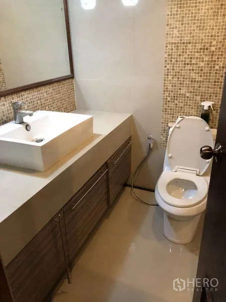 Condominium for rent in Watthana, Bangkok - Second bathroom with mosaic accent wall, vanity and toilet.