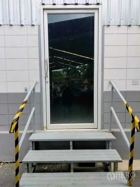 货栈 出租在Lat Krabang, Bangkok - 带阶梯与黄黑警示栏的玻璃门入口