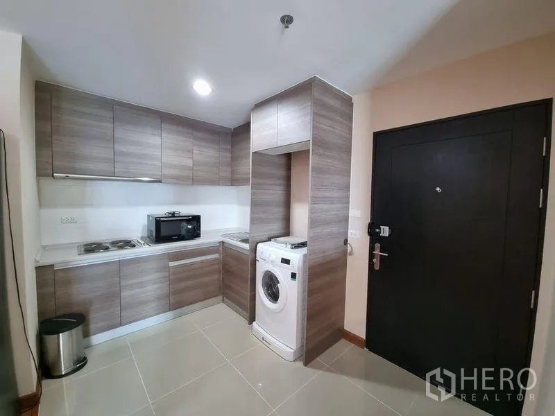 คอนโด ให้เช่าในHuai Khwang, Bangkok - ครัวรูปตัวแอลสมัยใหม่ ตู้บิวท์อิน เครื่องซักผ้า และประตูทางเข้า