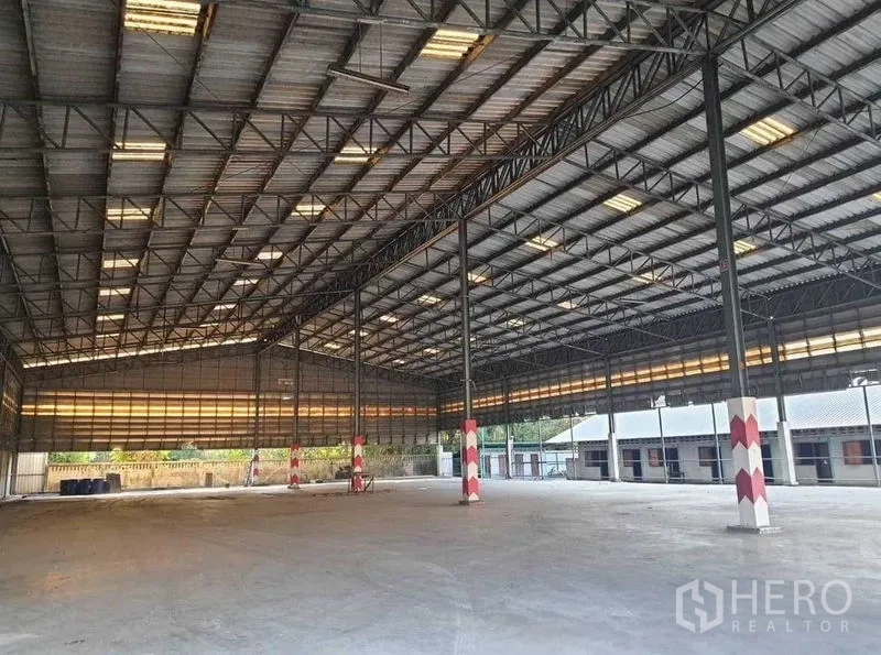 Warehouse for rent or sale in Mueang Pathum Thani, Pathum Thani - Wide clear warehouse hall with tall roof, steel columns and polished concrete flooring.