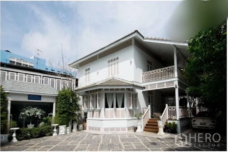 独立式住宅 出租在Bang Rak, Bangkok - 两层独栋住宅的广角外观，铺石庭院与停车位。