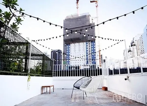Retail Space for rent in Khlong Toei, Bangkok - Rooftop terrace with string lights, city skyline views and lounge chairs in Sukhumvit.