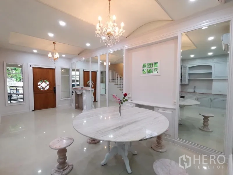 Townhouse for rent in Yan Nawa, Bangkok - Elegant dining hall with chandeliers, marble round table, full-height mirrors and staircase.