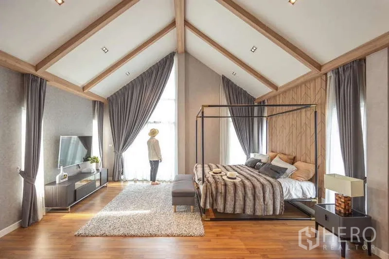 Detached House for sale in Lam Luk Ka, Pathum Thani - Master suite angle showing high gable ceiling, large windows and TV console.