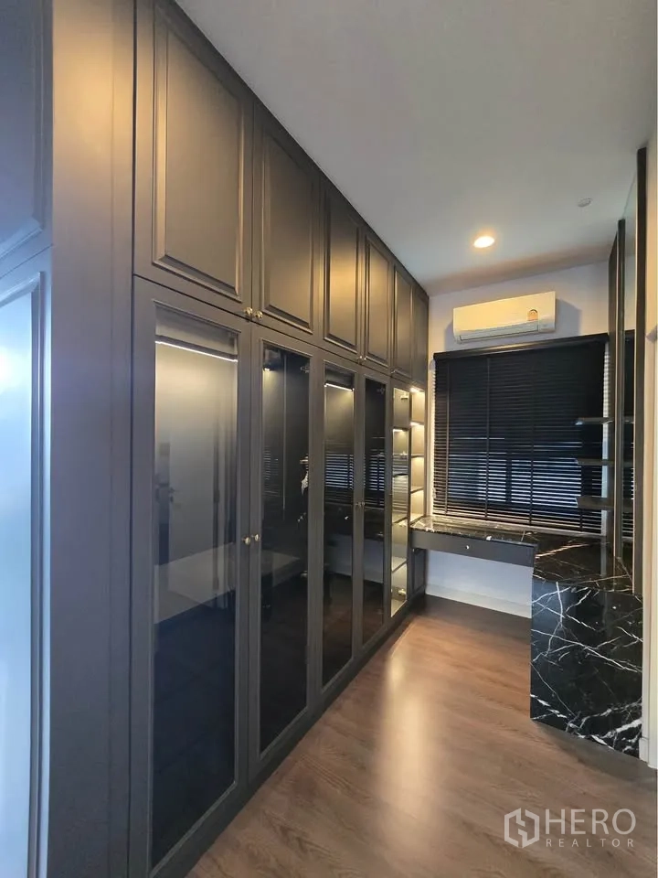 Detached House for rent in Bang Kapi, Bangkok - Walk-in wardrobe with glass-front cabinets and a dressing table.