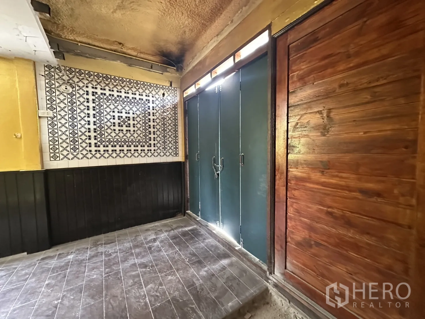 零售空间 出租在Bang Rak, Bangkok - 入口大堂铺花纹地砖，配金属门与木质推拉门。
